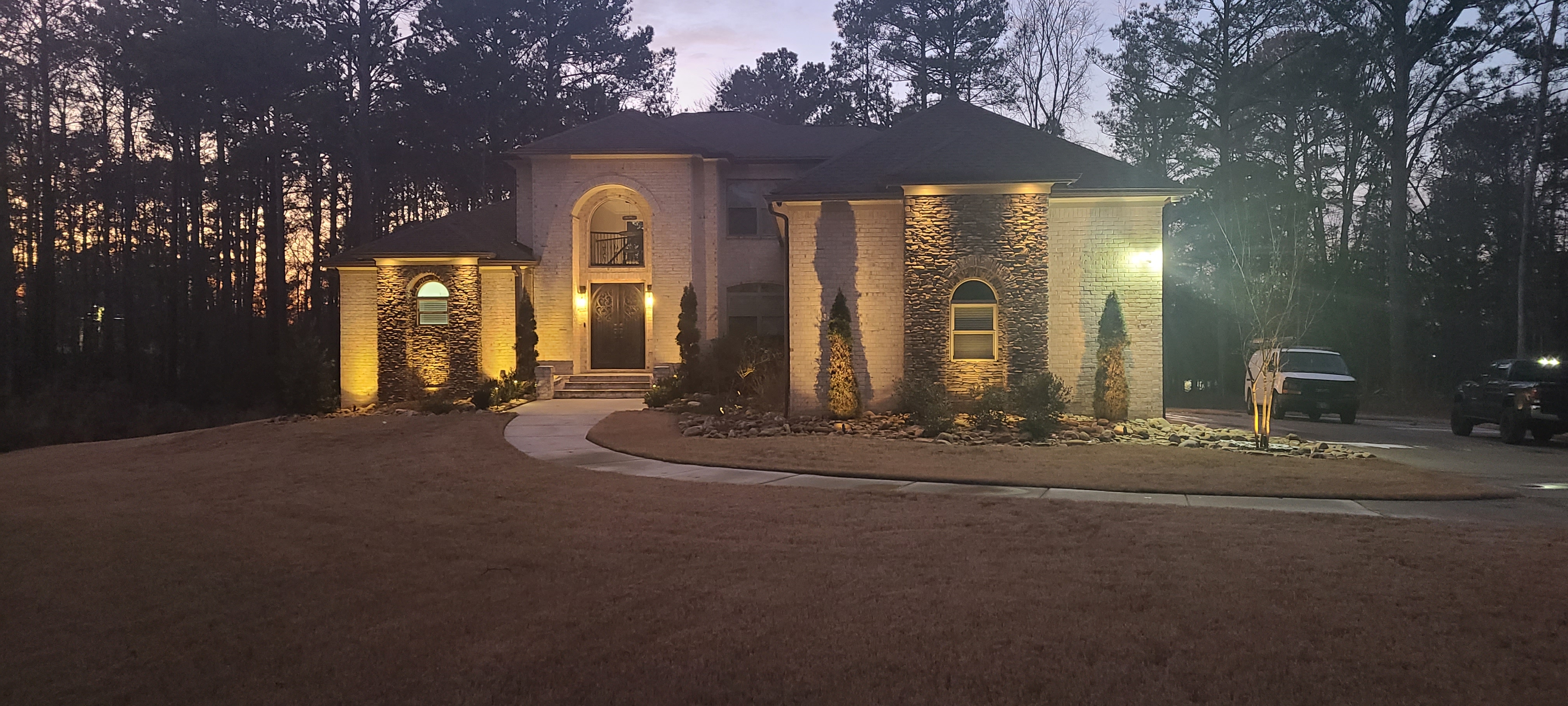 Brick and stone estate dramatically uplit at twilight